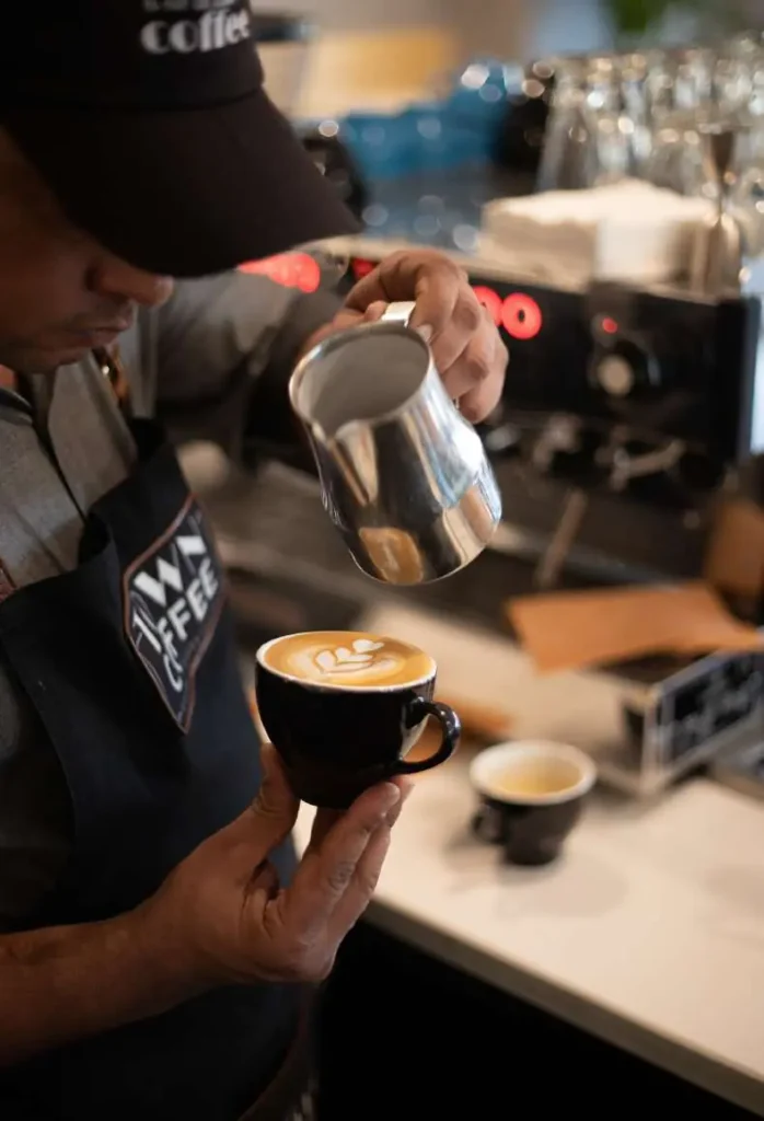 Barista pouring latte art at Town Coffee, Jaipur